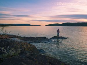 A man stands on an island in Christie Bay, one of the entry points to Thaidene Nene National Park Reserve.
